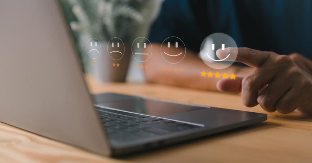 Persona valorando con estrellas en una pantalla digital, representando la reputación online de una empresa.